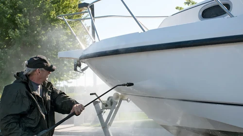 Man power washing boat