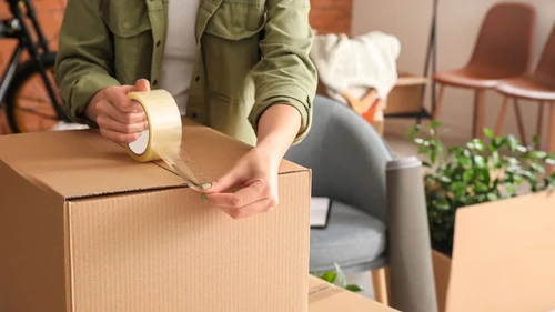 Woman taping up a box for storage
