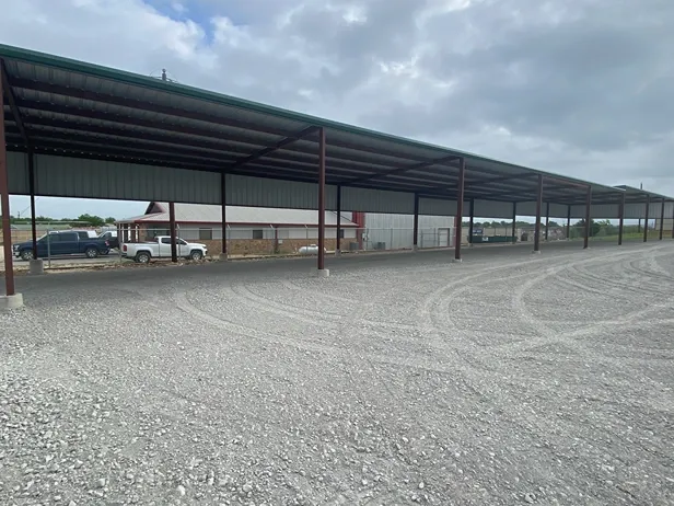 Outdoor covered vehicle storage with gravel surface at Rio Vista Mini Storage.