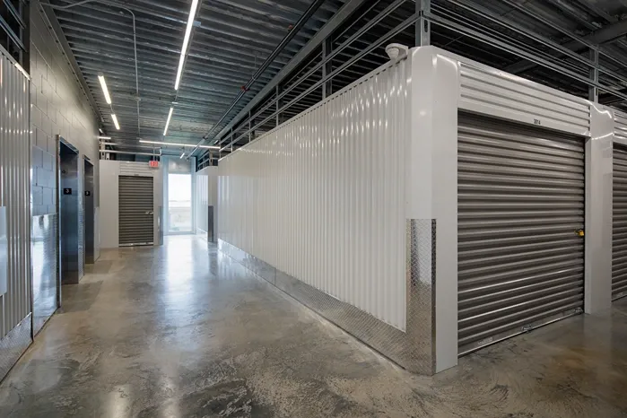 Bright corridor with clean roll-up doors at Storage Lounge.