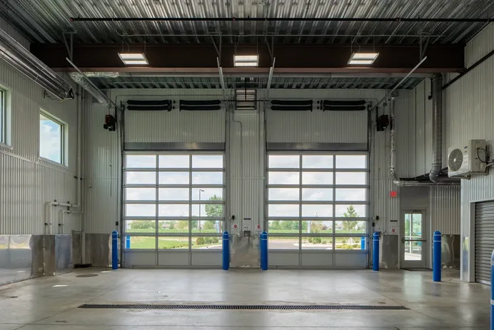Interior warehouse section with large doors and concrete flooring at Storage Lounge.