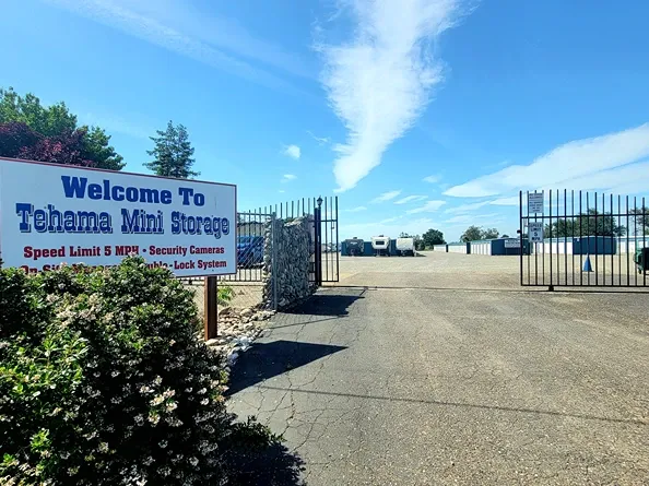 Exterior of Tehama Mini Storage facility with entrance sign and open gate.
